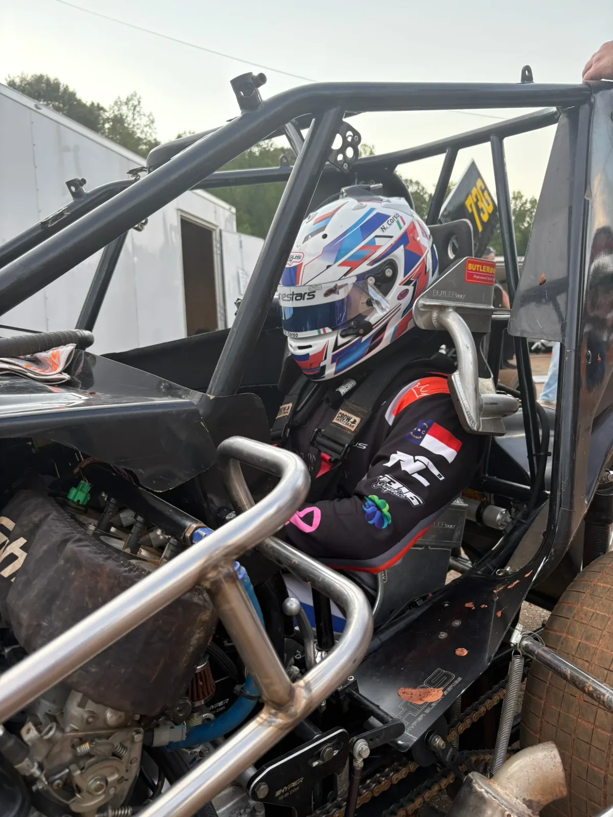 Strapped into a micro sprint, helmet on